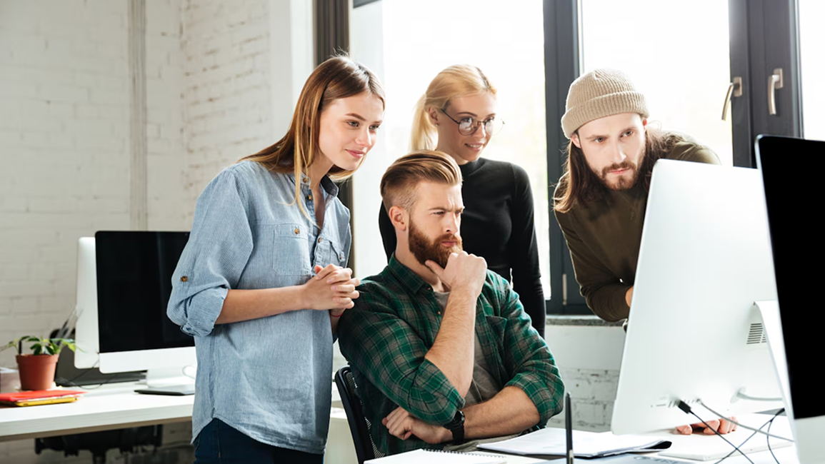 Team collaborating in front of a computer