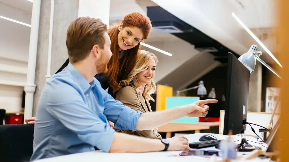 Team collaborating in front of a computer